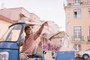 Tuk tuk driver providing tour of the city to a tourist, Lisbon, Portugal