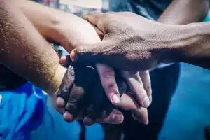 Diverse group of people joining hands in unity, support and team work gesture.Close up shot of hands