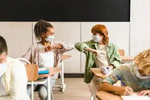 Schoolgirls classmates pupils students protecting against coronavirus Covid19