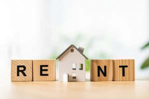 house model near wooden cubes with rent lettering on table