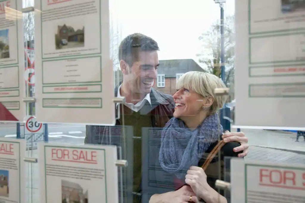 Couple looking into estate agents window