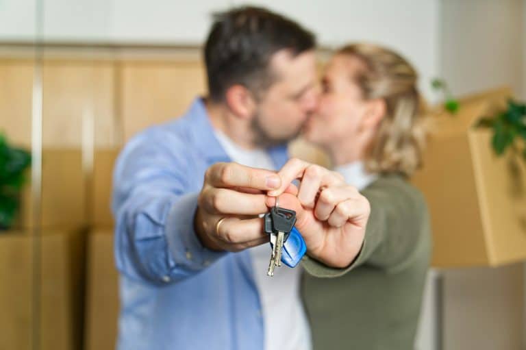 Couple showing keys to new apartment. real estate mortgage, loan concept. moving in new house