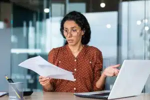 Frustrated and sad business woman holding financial report in hands, Hispanic woman sad working in