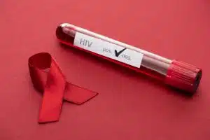 red awareness aids ribbon and negative hiv blood sample test on red background